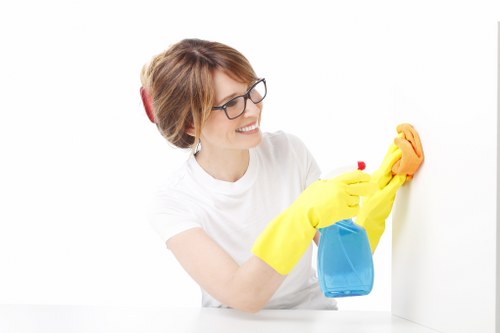 Cleaner using protective gloves and PPE during oven cleaning