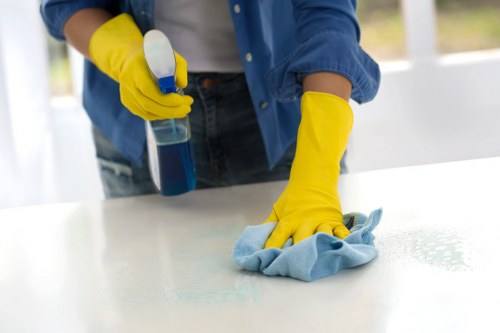 Close-up of oven cleaning process with protective gloves and cleaning tools